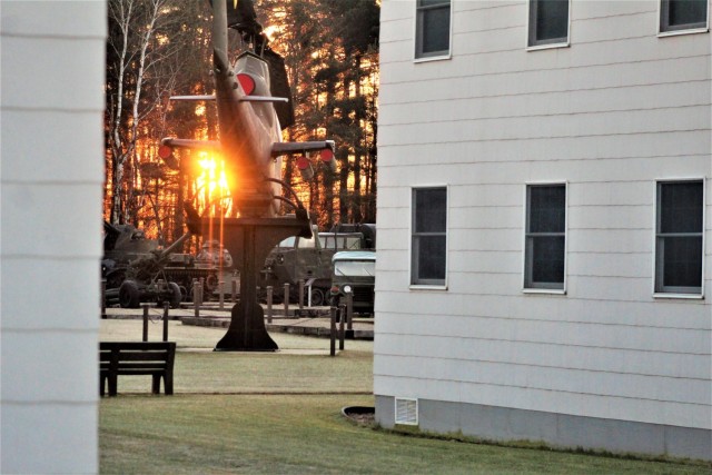 A frosty morning is slowly warmed with the rays of the sun glowing through the trees Dec. 10, 2020, at the Equipment Park in the historic Commemorative Area at Fort McCoy, Wis. Morning temperatures in the 20s caused widespread frost. (U.S. Army...