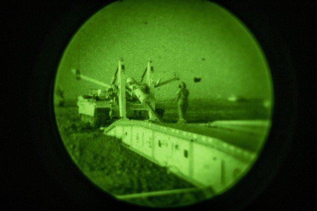 A Soldier with Bravo Company, 1st Engineer Battalion, 1st Armored Brigade Combat Team, 1st Infantry Division, Fort Riley, Kan., guides the Joint Assault Bridge to place the Heavy Assault Scissor Bridge over an anti-vehicle obstacle during operational testing at night.  The JAB is an armored bridging capability built on a modified M1A1 Abrams chassis designed to modernize the Engineer Regiment&#39;s bridging capabilities.  The JAB will be fielded in the Army&#39;s Active, Reserve, and National Guard components.