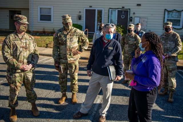 FORT BENNING, Ga. – The Maneuver Center of Excellence command team, consisting of Maj. Gen. Patrick J. Donahoe, commanding general, Command Sgt. Maj. Derrick C. Garner, command sergeant major, and Kirk Ticknor, Housing chief, discuss the neighborhood's trash pickup with Spc. Carletha Ingram, 1st Battalion, 28th Infantry Regiment, Dec. 9, 2020, at Bouton Heights.  
(U.S. Army photo by Patrick A. Albright, Maneuver Center of Excellence and Fort Benning Public Affairs)