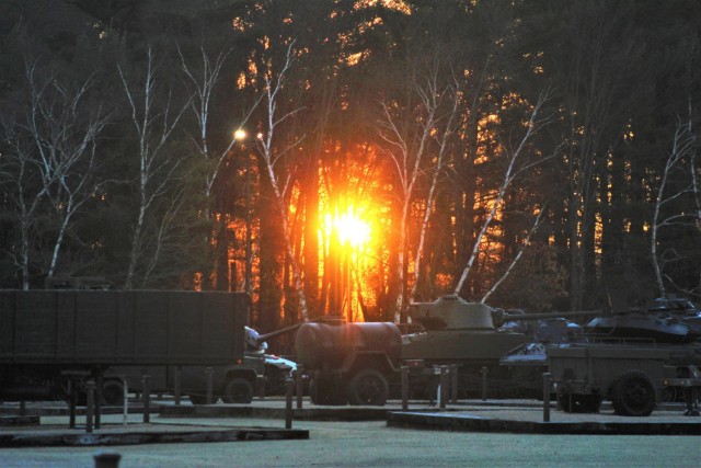 A frosty morning is slowly warmed with the rays of the sun glowing through the trees Dec. 10, 2020, at the Equipment Park in the historic Commemorative Area at Fort McCoy, Wis. Morning temperatures in the 20s caused widespread frost. (U.S. Army...