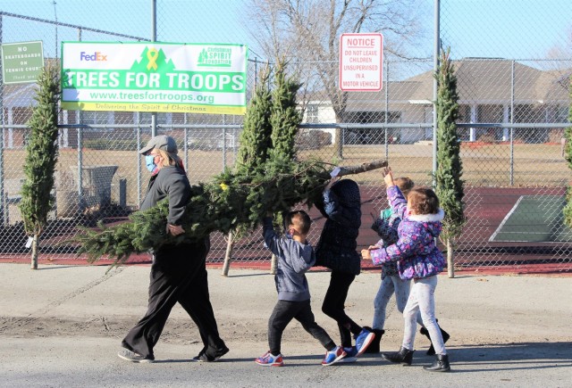 Military family members carry a tree Dec. 4, 2020, during the Trees for Troops event at the South Post Housing area at Fort McCoy, Wis. Eighty free Christmas trees were distributed to Fort McCoy military families thanks to the Trees for Troops organization. This was fifth consecutive year the trees were distributed. The Directorate of Public Works Housing Division coordinated the distribution. (U.S. Army Photo by Scott T. Sturkol, Public Affairs Office, Fort McCoy, Wis.)