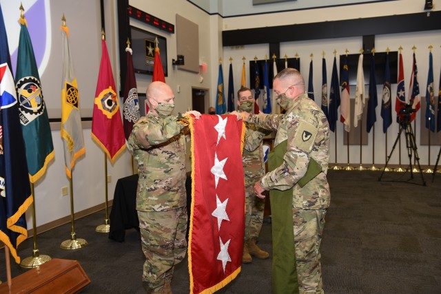 Gen. Ed Daly, the new commander of the Army Materiel Command, unfurls his four-star flag during his promotion ceremony July 2 at Army Materiel Command headquarters, Redstone Arsenal, Alabama. Assisting him, at right, is AMC Command Sgt. Maj....