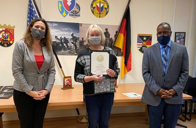 The 405th Army Field Support Brigade deputy commanding officer, Jody Fasko, presents a certificate of recognition to Sabine Gundacker for 30 years of service in the government of the United States of America. Gundacker was recognized at the...