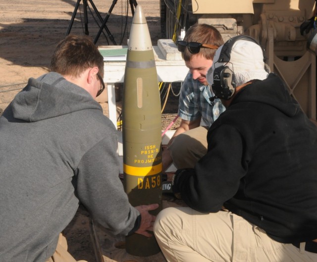 Prior to firing the projectile from the Extended-Range Cannon Artillery members of the team inspect the test item.