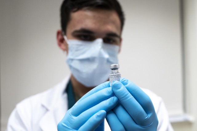 Army Spc. Angel Laureano holds a vial of the COVID-19 vaccine at Walter Reed National Military Medical Center, Bethesda, Md., Dec. 14, 2020.