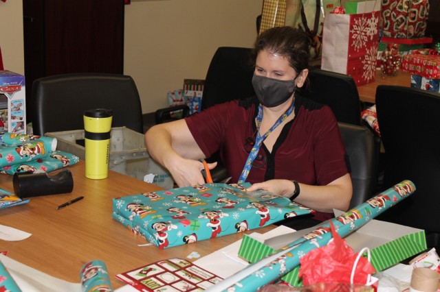 Cynthia Judd, a biological systems engineer, prepares a gift for delivery to the Fort Sam Houston Elementary School as part of the Adopt-A-School program. 