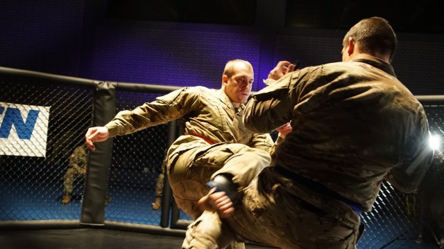 U.S. Army Pfc. Austin Denham (left), assigned to the 1st Squadron, 2d Cavalry Regiment, kicks Sgt. Zachary Morro (right), assigned to the 3rd Squadron, 2CR, during the 2CR Fight Night Round Two event at the Memorial Gym, Rose Barracks, Germany, Dec. 11, 2020. 2CR Fight Night is an annual modern Army combatives program event that enables Soldiers to challenge each other - head-to-head - at a chance to win trophies and receive recognition among their peers. (U.S. Army photo by Staff Sgt. William Rawlins)