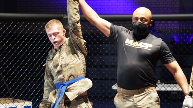 U.S. Army Staff Sgt. Jonathan Munas (left), assigned to the 4th Squadron, 2d Cavalry Regiment, wins the light weight title during the 2CR Fight Night Round Two event at the Memorial Gym, Rose Barracks, Germany, Dec. 11, 2020. 2CR Fight Night is an annual modern Army combatives program event that enables Soldiers to challenge each other - head-to-head - at a chance to win trophies and receive recognition among their peers. (U.S. Army photo by Staff Sgt. William Rawlins)