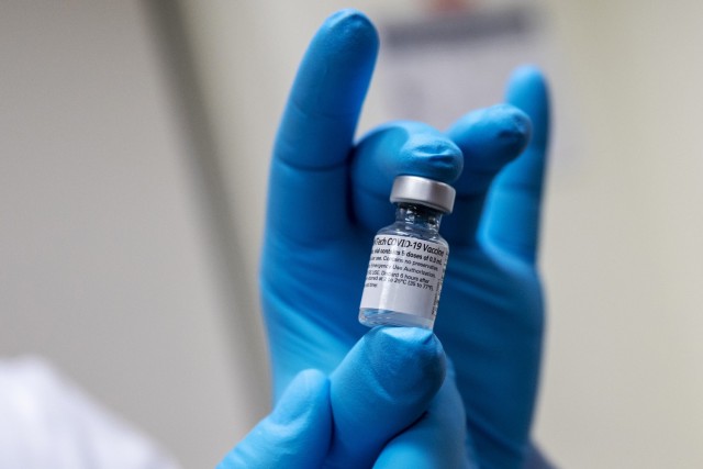 Army Spc. Angel Laureano holds a vial of the COVID-19 vaccine at Walter Reed National Military Medical Center, Bethesda, Md., Dec. 14, 2020.