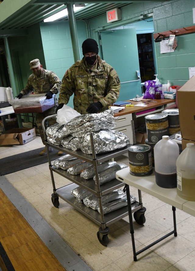 First Sgt. Raymond Huff and Sgt. 1st Class Eric Guzman, both members of the Fort Drum Sgt. Audie Murphy Club, deliver provisions for a hearty meal to the Watertown Salvation Army on Dec. 15. The Soldiers made another food delivery to support...