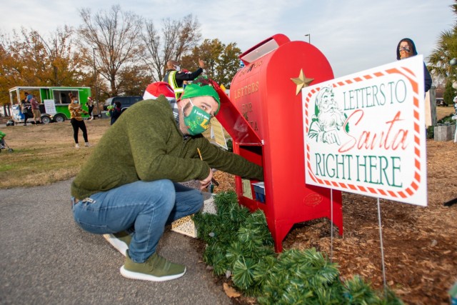 Colin Henderson, one of Santa’s helpers from the Directorate of Family and Moral, Welfare and Recreation reaches into a mailbox to gather some of the 200 letters written to Santa by Fort Jackson children.