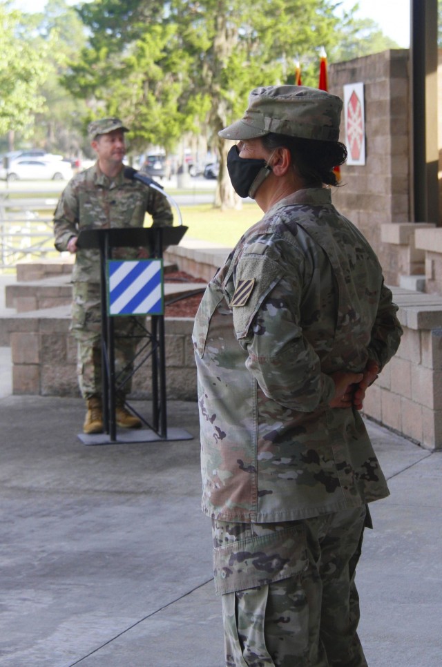 Command Sgt. Maj. Paulette Abraham, right, stands at parade rest while Lt. Col. Kelly McCay, Headquarters and Headquarters Battalion commander, 3rd Infantry Division, addresses attendees during a change of responsibility ceremony at Marne Garden on Fort Stewart, Georgia, Oct. 23, 2020. McCay expressed his appreciation for Abraham's selfless leadership over the past two years in his remarks.(U.S. Army photo by Pfc. Aaliyah Craven, 50th Public Affairs Detachment)