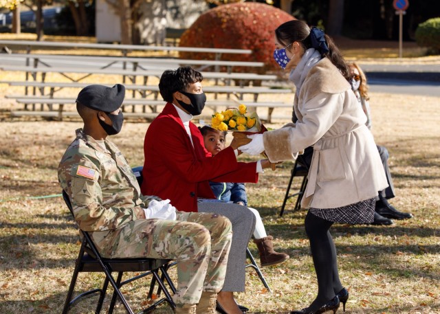 Royall Turner, spouse of incoming U.S. Army Garrison Japan Command Sgt. Maj. Justin E. Turner, receives a bouquet of yellow roses during her husband’s assumption of responsibility ceremony at Camp Zama, Japan, Dec. 17.