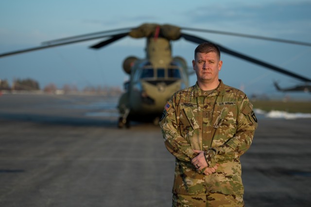 Chief Warrant Officer 2 Dave Acton, CH-47F Chinook pilot assigned to B Company, 6th General Support Aviation Battalion, 101st Combat Aviation Brigade, 101st Airborne Division (Air Assault), stands in front of a helicopter at Storck Barracks in Illesheim, Germany, Dec. 16, 2020. Acton, three other flight crew members, and a medical officer from the CAB landed in a field to provide medical assistance following a car accident they witnessed while flying back to Illesheim from a routine training mission, Dec. 15, 2020. (U.S. Army National Guard photo by Staff Sgt. Garrett L. Dipuma)