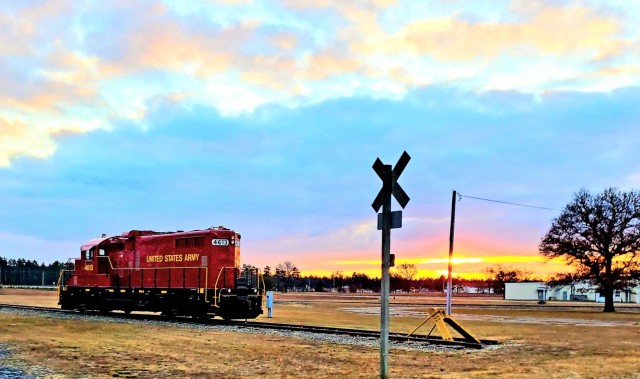 A U.S. Army locomotive used as part of rail operations is shown Dec. 16, 2020, at sunset at Fort McCoy, Wis. For the many decades of Fort McCoy’s existence, the capability to transport cargo and equipment to and from the installation by rail has always been there. During World War II, for example, the railroad at Fort McCoy was one of the main forms of transportation for bringing troops in for training and home after the war as well as moving cargo and equipment in and out of the installation. And as rail operations continue in the future at the installation, Fort McCoy's Transportation Officer D.J. Eckland with LRC said he welcomes each and every opportunity to demonstrate the capability. He said rail is one of the post's strategic transportation missions, and regular rail movements allow the installation to exercise that capability. (U.S. Army Photo by Scott T. Sturkol, Public Affairs Office, Fort McCoy, Wis.)