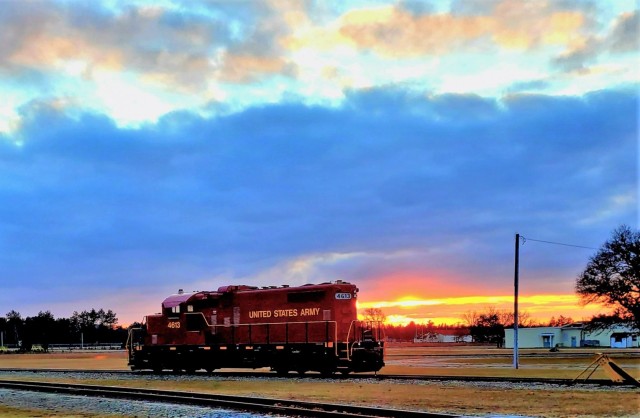 A U.S. Army locomotive used as part of rail operations is shown Dec. 16, 2020, at sunset at Fort McCoy, Wis. For the many decades of Fort McCoy’s existence, the capability to transport cargo and equipment to and from the installation by rail has always been there. During World War II, for example, the railroad at Fort McCoy was one of the main forms of transportation for bringing troops in for training and home after the war as well as moving cargo and equipment in and out of the installation. And as rail operations continue in the future at the installation, Fort McCoy's Transportation Officer D.J. Eckland with LRC said he welcomes each and every opportunity to demonstrate the capability. He said rail is one of the post's strategic transportation missions, and regular rail movements allow the installation to exercise that capability. (U.S. Army Photo by Scott T. Sturkol, Public Affairs Office, Fort McCoy, Wis.)