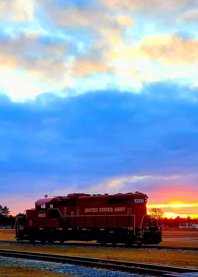 A U.S. Army locomotive used as part of rail operations is shown Dec. 16, 2020, at sunset at Fort McCoy, Wis. For the many decades of Fort McCoy’s existence, the capability to transport cargo and equipment to and from the installation by rail has always been there. During World War II, for example, the railroad at Fort McCoy was one of the main forms of transportation for bringing troops in for training and home after the war as well as moving cargo and equipment in and out of the installation. And as rail operations continue in the future at the installation, Fort McCoy's Transportation Officer D.J. Eckland with LRC said he welcomes each and every opportunity to demonstrate the capability. He said rail is one of the post's strategic transportation missions, and regular rail movements allow the installation to exercise that capability. (U.S. Army Photo by Scott T. Sturkol, Public Affairs Office, Fort McCoy, Wis.)