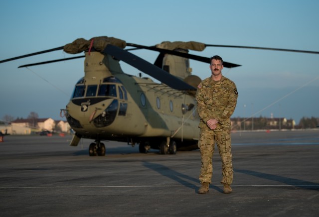 Chief Warrant Officer 2 Robert Riedel, a CH-47F Chinook pilot assigned to B Company, 6th General Support Aviation Battalion, 101st Combat Aviation Brigade, 101st Airborne Division (Air Assault), stands in front of a helicopter at Storck Barracks...