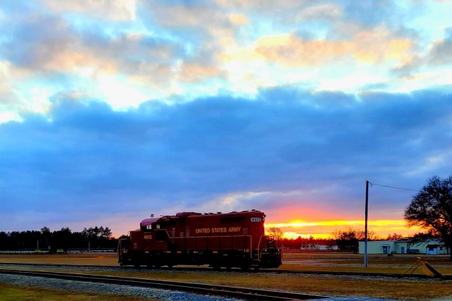 A U.S. Army locomotive used as part of rail operations is shown Dec. 16, 2020, at sunset at Fort McCoy, Wis. For the many decades of Fort McCoy’s existence, the capability to transport cargo and equipment to and from the installation by rail has always been there. During World War II, for example, the railroad at Fort McCoy was one of the main forms of transportation for bringing troops in for training and home after the war as well as moving cargo and equipment in and out of the installation. And as rail operations continue in the future at the installation, Fort McCoy's Transportation Officer D.J. Eckland with LRC said he welcomes each and every opportunity to demonstrate the capability. He said rail is one of the post's strategic transportation missions, and regular rail movements allow the installation to exercise that capability. (U.S. Army Photo by Scott T. Sturkol, Public Affairs Office, Fort McCoy, Wis.)