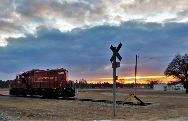 A U.S. Army locomotive used as part of rail operations is shown Dec. 16, 2020, at sunset at Fort McCoy, Wis. For the many decades of Fort McCoy’s existence, the capability to transport cargo and equipment to and from the installation by rail has always been there. During World War II, for example, the railroad at Fort McCoy was one of the main forms of transportation for bringing troops in for training and home after the war as well as moving cargo and equipment in and out of the installation. And as rail operations continue in the future at the installation, Fort McCoy's Transportation Officer D.J. Eckland with LRC said he welcomes each and every opportunity to demonstrate the capability. He said rail is one of the post's strategic transportation missions, and regular rail movements allow the installation to exercise that capability. (U.S. Army Photo by Scott T. Sturkol, Public Affairs Office, Fort McCoy, Wis.)