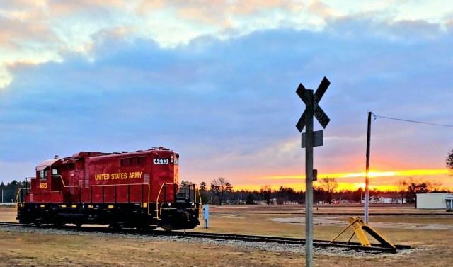 A U.S. Army locomotive used as part of rail operations is shown Dec. 16, 2020, at sunset at Fort McCoy, Wis. For the many decades of Fort McCoy’s existence, the capability to transport cargo and equipment to and from the installation by rail has always been there. During World War II, for example, the railroad at Fort McCoy was one of the main forms of transportation for bringing troops in for training and home after the war as well as moving cargo and equipment in and out of the installation. And as rail operations continue in the future at the installation, Fort McCoy's Transportation Officer D.J. Eckland with LRC said he welcomes each and every opportunity to demonstrate the capability. He said rail is one of the post's strategic transportation missions, and regular rail movements allow the installation to exercise that capability. (U.S. Army Photo by Scott T. Sturkol, Public Affairs Office, Fort McCoy, Wis.)