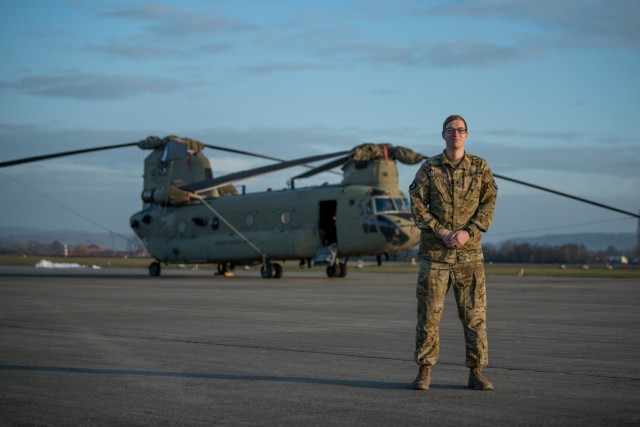 U.S. Army Spc. Bruce Cook, a CH-47F Chinook crew chief assigned to B Company, 6th General Support Aviation Battalion, 101st Combat Aviation Brigade, 101st Airborne Division (Air Assault), stands in front of a helicopter at Storck Barracks in Illesheim, Germany, Dec. 16, 2020. Cook, three other flight crew members, and a doctor from the CAB landed in a field to provide medical assistance following a car accident they witnessed while flying back to Illesheim from a routine training mission. (U.S. Army National Guard photo by Staff Sgt. Garrett L. Dipuma)
