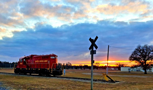 A U.S. Army locomotive used as part of rail operations is shown Dec. 16, 2020, at sunset at Fort McCoy, Wis. For the many decades of Fort McCoy’s existence, the capability to transport cargo and equipment to and from the installation by rail has always been there. During World War II, for example, the railroad at Fort McCoy was one of the main forms of transportation for bringing troops in for training and home after the war as well as moving cargo and equipment in and out of the installation. And as rail operations continue in the future at the installation, Fort McCoy's Transportation Officer D.J. Eckland with LRC said he welcomes each and every opportunity to demonstrate the capability. He said rail is one of the post's strategic transportation missions, and regular rail movements allow the installation to exercise that capability. (U.S. Army Photo by Scott T. Sturkol, Public Affairs Office, Fort McCoy, Wis.)