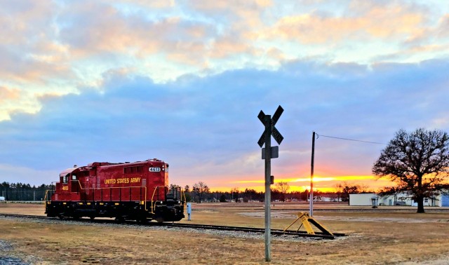 A U.S. Army locomotive used as part of rail operations is shown Dec. 16, 2020, at sunset at Fort McCoy, Wis. For the many decades of Fort McCoy’s existence, the capability to transport cargo and equipment to and from the installation by rail has always been there. During World War II, for example, the railroad at Fort McCoy was one of the main forms of transportation for bringing troops in for training and home after the war as well as moving cargo and equipment in and out of the installation. And as rail operations continue in the future at the installation, Fort McCoy's Transportation Officer D.J. Eckland with LRC said he welcomes each and every opportunity to demonstrate the capability. He said rail is one of the post's strategic transportation missions, and regular rail movements allow the installation to exercise that capability. (U.S. Army Photo by Scott T. Sturkol, Public Affairs Office, Fort McCoy, Wis.)