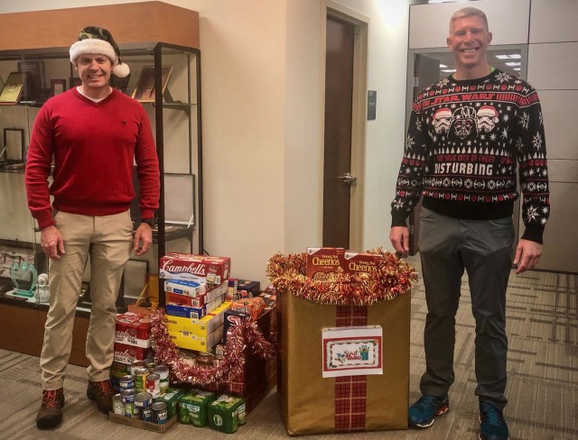 Brig. Gen. John Kline, the U.S. Army Training and Doctrine Command Chief of Operations, Plans and Training G-3/5/7 (left) and Command Sgt. Maj. Thomas Baird, G-3/5/7 Command Sergeant Major, pose next to food donations from the G-3/5/7 staff at TRADOC Headquarters, Fort Eustis, VA, which are intended for local food banks in the Hampton Roads, Virginia, area, Dec. 18, 2020. (U.S. Army photo by Nina Borgeson)