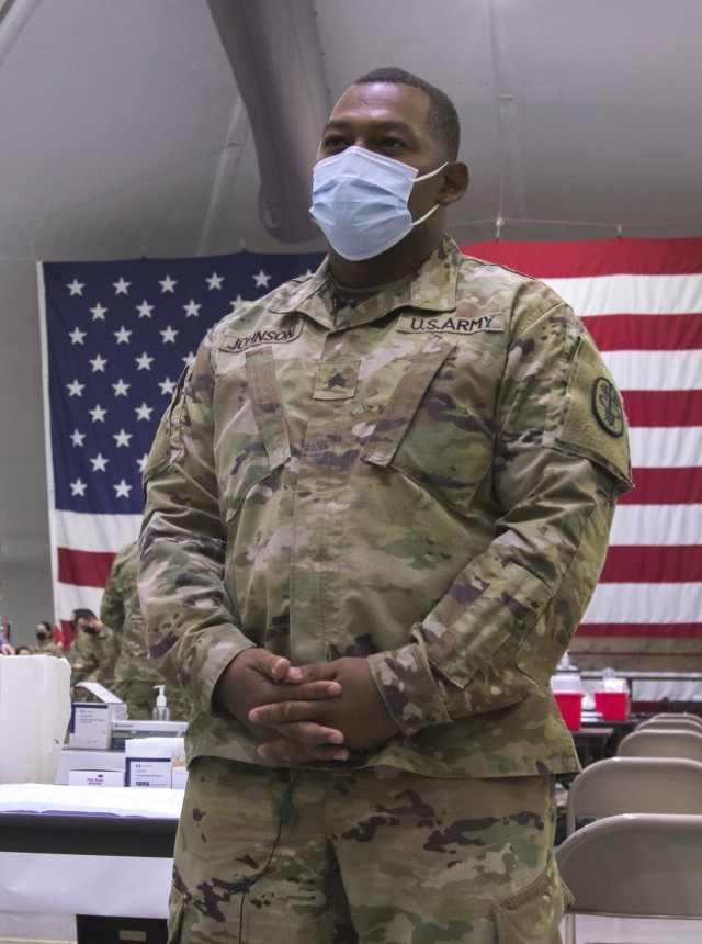 Sgt. Jason Johnson, a medic at the Irwin Army Community Hospital is the first Soldier to vaccinate a medical professional on December 23 on Fort Riley, Kansas. Healthcare professionals hold a priority in receiving the vaccination before other personnel.