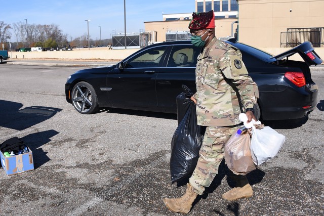 Command Sgt. Maj. Finis Dodson, command sergeant major, U.S. Army Space and Missile Defense Command, unloads bags from a donator's vehicle during a donation drive hosted by USASMDC noncommissioned officers at the command’s Redstone Arsenal...