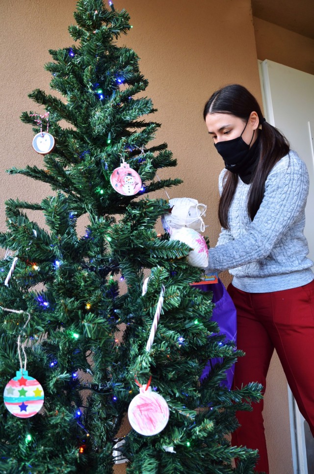 VICENZA, Italy - Emily Coyle, Sergeant Morales Club member decorates one of the eight Christmas trees before delivering them to Villaggio Army Family Housing Dec. 18, 2020.
“We helped decorate trees in the quarantine building with ornaments made by the children of this wonderful community. Looking at these ornaments, you could feel the love these children put into sharing their jolly Christmas spirits,” said Coyle.

Approximately 20 volunteers from 12 different organizations and agencies within the Vicenza military community have come together to provide a little holiday cheer for the new members of the local community. In addition to delivering Christmas trees, their volunteering included delivering cards, stockings and fully cooked holiday meals to Soldiers and Families quarantined on Villaggio.