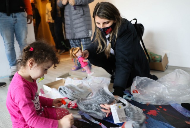 BUCHAREST, Romania – Roxana Sandu, Regional Leader, Salvation Army, Romania goes through presents with a young girl in her living room here on Dec. 21. Through the combined efforts of Civil Affairs Team 3231, 432nd Civil Affairs Battalion, Green...