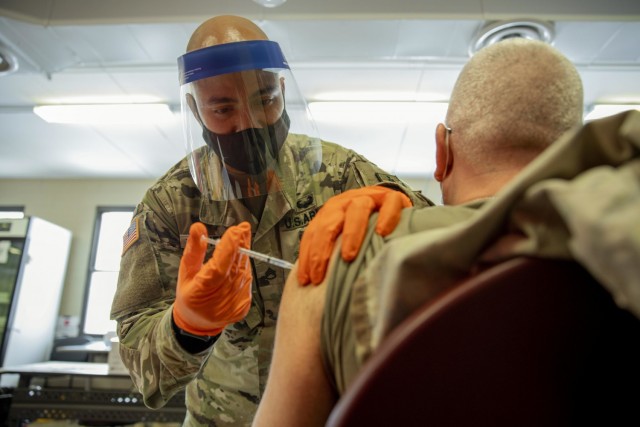 Army Staff Sgt. Nigel Chen, a New York National Guardsman, administers the Pfizer-BioNTech COVID-19 vaccine at the Camp Smith Training Site Medical Readiness Clinic, N.Y., Dec. 18, 2020. The New York National Guard is administering 44,000 doses of the Pfizer vaccine to front line medical personnel at 16 locations around the world as part of a pilot program.