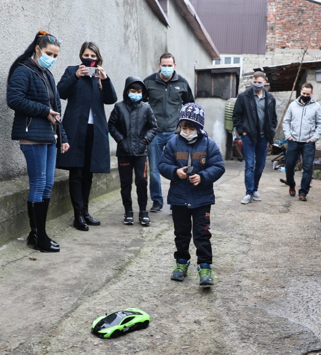 BUCHAREST, Romania – Roxana Sandu, Regional Leader, Salvation Army, Romania and members of Civil Affairs Team 3231, 432nd Civil Affairs Battalion, Green Bay, Wis., look on with a boy and his mother as the younger brother plays with his new...
