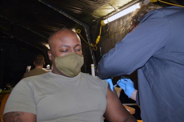 U.S. Army Staff Sgt. Jamaal Cromer, an Army medic assigned to U.S. Army Health Clinic Ansbach, receives the Moderna COVID-19 vaccine from Nurse Claudia Aikens at USAHC Ansbach Clinic, Ansbach, Germany, Dec. 28, 2020. Cromer is the first to receive the COVID-19 vaccine in the Ansbach military community.