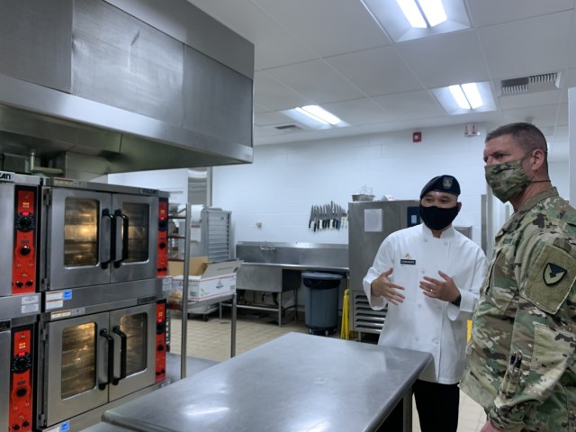 Staff Sgt. Cabansag briefs Maj. Gen. Daniel Mitchell, commanding general of the Army Sustainment Command on the updated equipment in the kitchen and the increased capability that the equipment provides for his cooks.