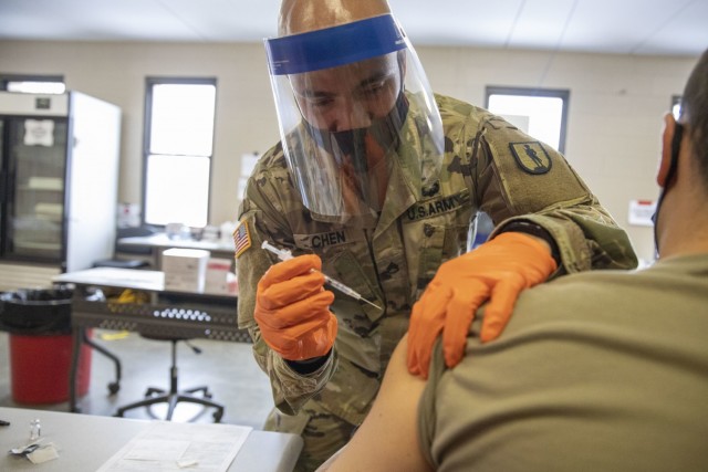 U.S. Army Staff Sgt. Nigel Chen, assigned to Joint Task Force COVID-19, New York National Guard, administers the Pfizer-BioNTech COVID-19 vaccine at the Camp Smith Training Site Medical Readiness Clinic, N.Y., on Dec. 18, 2020. The New York...