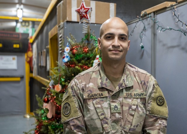 New York Police Officer and U.S. Army Staff Sgt. Samuel Garcia, intelligence analyst noncommissioned officer, 719th Movement Control Battalion, poses for a photo after a special holiday call from New York City Police Commissioner Dermot Shea at Camp Arifjan, Kuwait, Dec 23, 2020. During the call Shea thanked Garcia for his continued service to the nation as he serves his country in support of Operation Spartan Shield. (U.S. Army photo by Spc. Zoran Raduka, 1st TSC Public Affairs)