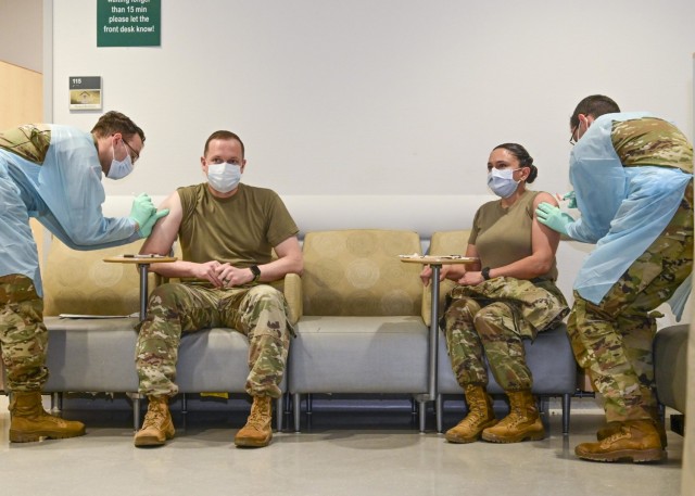 U.S. Army Lt. Col. Adam Cronkhite (seated left), Director of Emergency Services, and U.S. Army Lt. Col. Maria Bruton (seated right), commander of U.S. Army Health Clinic Stuttgart, simultaneously were the first to receive the COVID-19 vaccine in the Stuttgart military community.