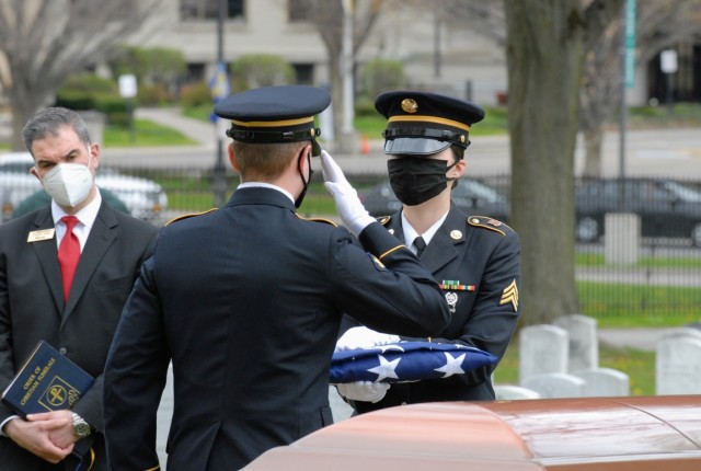 Spc. Austin Dycha renders a final salute to the American flag held by Sgt. Nikole Clark during the funeral of former U.S. Army Spc. Levelzo Lyles in Buffalo, New York, May 14. As part of precautions against the spread of COVID-19, the a members of the New York National Guard Military Funeral Honors Team wore face masks and maintained social distancing during the funeral. (Army National Guard Photo by Capt. Avery Schneider)