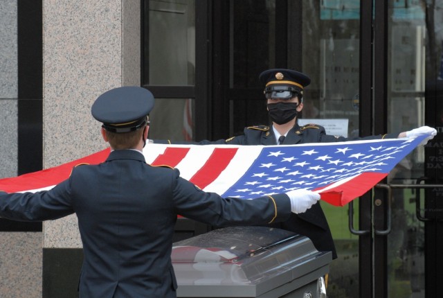 Spc. Austin Dycha and Sgt. Nikole Clark, members of the New York National Guard Military Funeral Honors Team, remove the flag of the United States from the casket of U.S. Army Air Force Cpl. Raymond Kegler at his funeral in Lackawanna, New York, May 14. Dycha and Clark wore face masks as part of precautions being used during military funerals to prevent the spread of COVID-19. (Army National Guard Photo by Capt. Avery Schneider)