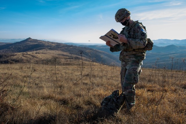 A Soldier assigned to Kosovo Force, Regional Command-East, confirms coordinates during a helicopter landing site clearance operation in Kosovo on Dec. 23, 2020. KFOR ensures a safe and secure environment by regularly patrolling the administrative...