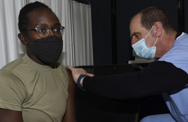 Staff Sgt. Yolande Allen receives a dose of COVID-19 vaccine from Douglas Sutton during a vaccine rollout at Camp Johnson, Vermont, Jan. 4, 2021. The Vermont National Guard received 200 doses of the Moderna vaccine in late December. Allen is a...