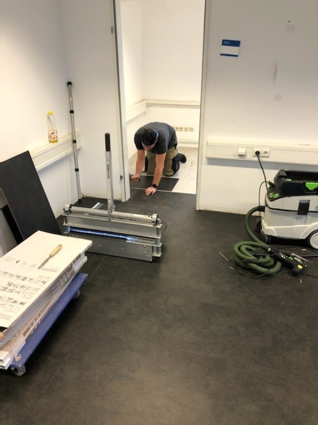 WIESBADEN, Germany - A U.S. Army Garrison Wiesbaden Directorate of Public Works employee installs tile in a day room in the barracks on Clay Kaserne as part of a plan to upgrade Soldier quarters and improve quality of life.