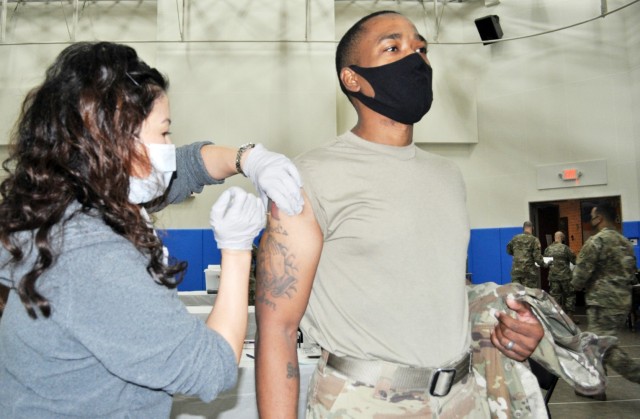 Command Sgt. Maj. Justin Turner, command sergeant major for U.S. Army Garrison Japan, receives a COVID-19 vaccine shot at the Community Recreation Center, Camp Zama, Japan, Jan. 6. Emiri Elliot, head nurse of the family clinic at Brig. Gen....