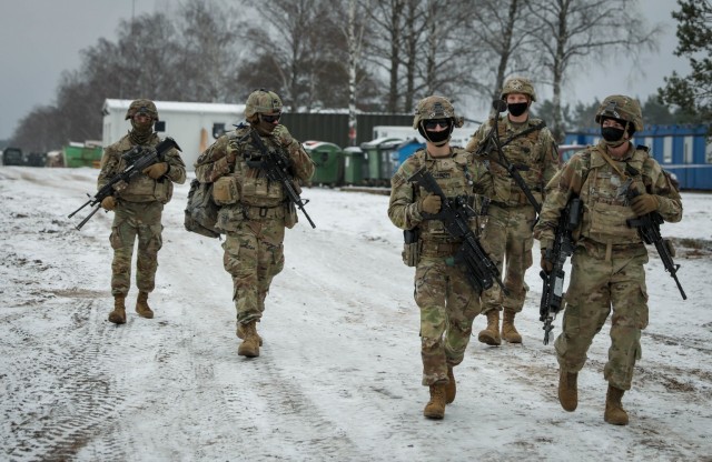 Troopers assigned to 2nd Battalion, 8th Cavalry Regiment, 1st Armored Brigade Combat Team, 1st Cavalry Division, march down the Pabrade Training Area, Lithuania, range road as they support a live fire demonstration Dec. 22, 2020.