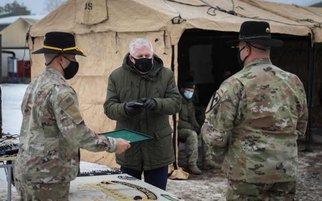 Lithuanian Minister of Defense Arvydas Anusaukas exchanges challenge coins with 2nd Battalion, 8th Cavalry Regiment, 1st Armored Brigade Combat Team, 1st Cavalry Division Commander Lt. Col. Steven E. Jackowski during a Jan. 4, 2021, color uncasing...