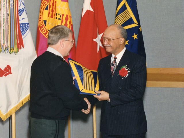 Retirement ceremony for Robert Swint (right), Director Integrated Materiel Management Center.  He is being presented his retirement certificate and Tank-automotive and Armaments Command memorabilia from Maj. Gen. Edward Andrews (left), former Commanding General TACOM, at the Detroit Arsenal, Michigan in March 1996. 