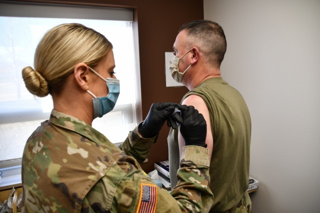 Col. James Hesterberg, the United States Property and Fiscal Officer, receives his first dose of the Moderna COVID -19 vaccine from Capt. Kaleigh Koeppen at the Fort Harrison Medical Detachment Jan. 5, 2021.